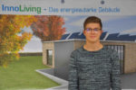 Der duale Student steht vor einem Plakat des energieautarken Gebäude.